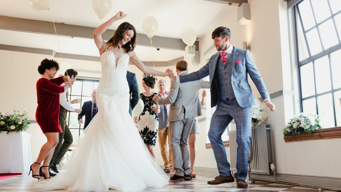 Bride and groom dance with guests at their wedding reception