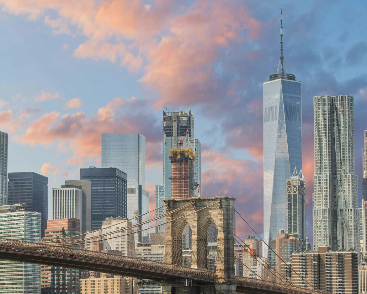 New York skyline at dusk with the Brooklyn bridge, an engagement photo location, in the foreground