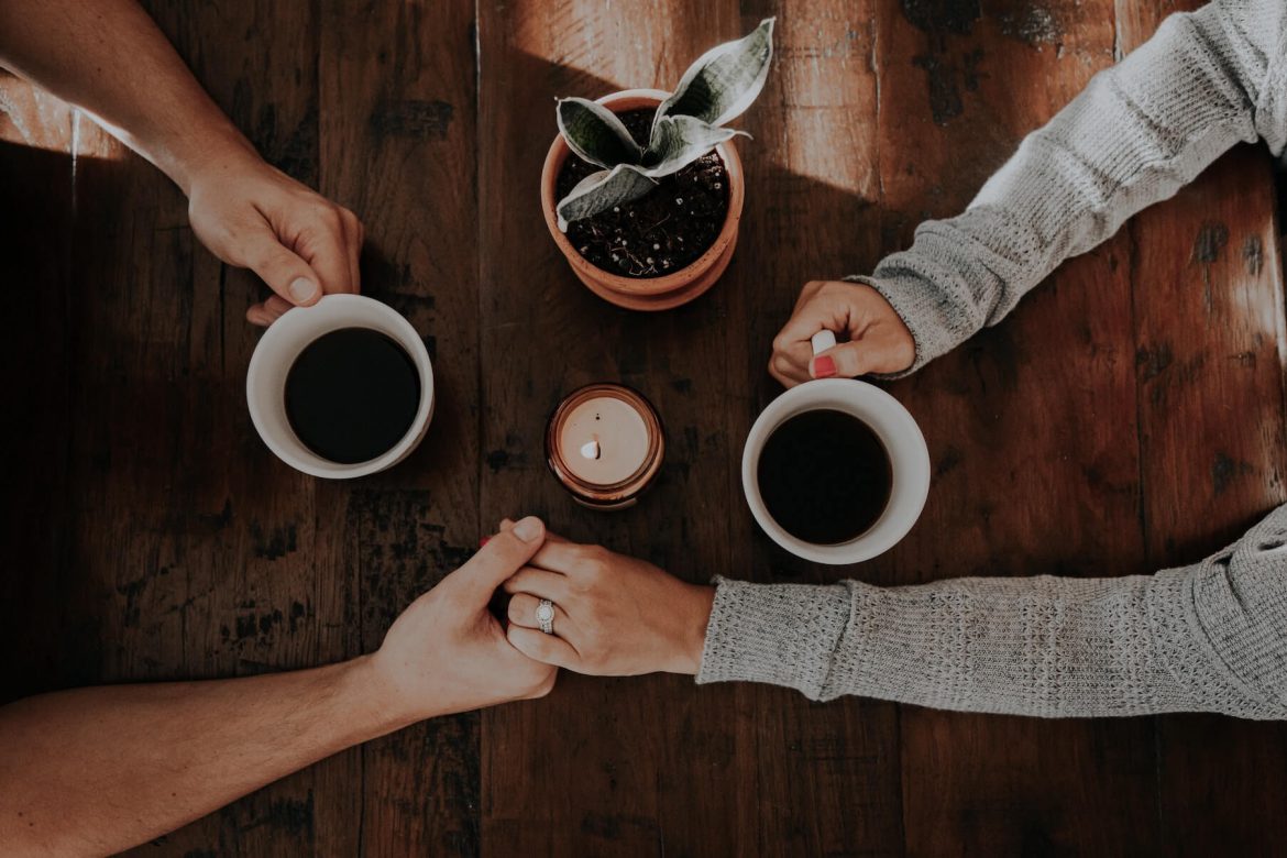 Couple holding hands at table