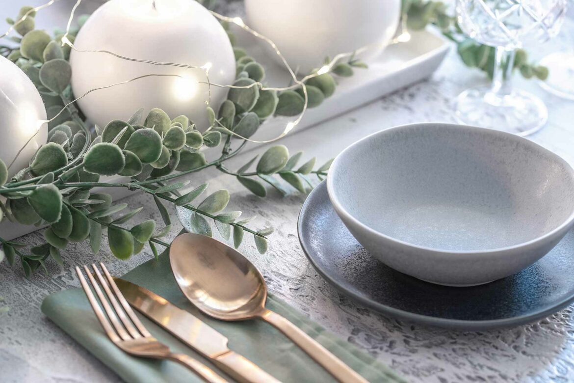 A dinnerware set with an accent plate and bowl to the right of a flatware setting